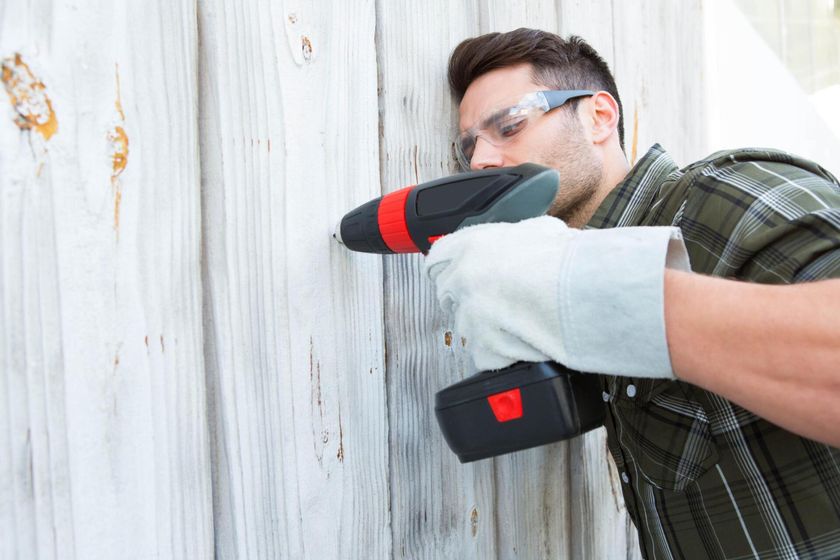man repairing wooden fence in Mission Viejo