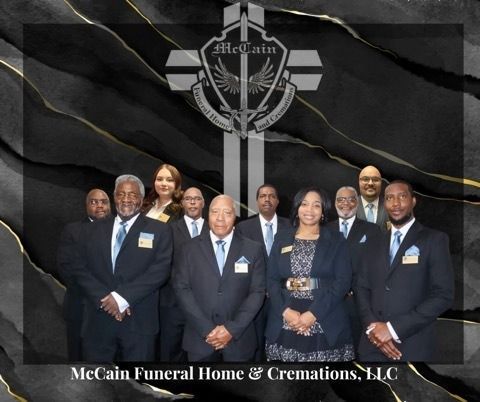 A group of ten professionals in formal suits stand before a dark, abstract background with the McCain Funeral Home logo.