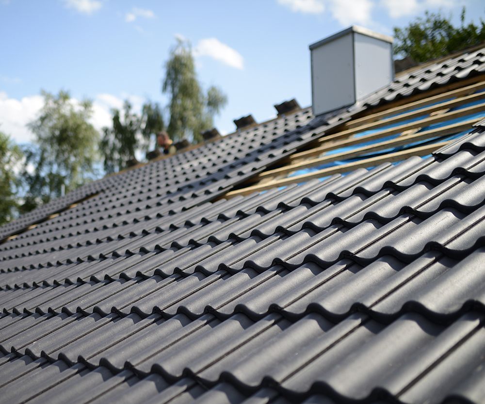 Gray gutter system on a building's edge, blue sky in the background.