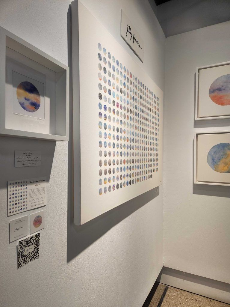 Gallery wall with framed prints and a QR code in a corner exhibit