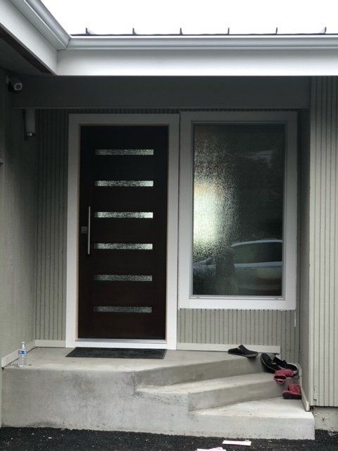 The front door of a house with stairs leading up to it — Tukwila, WA — Bel-Red Windows & Doors