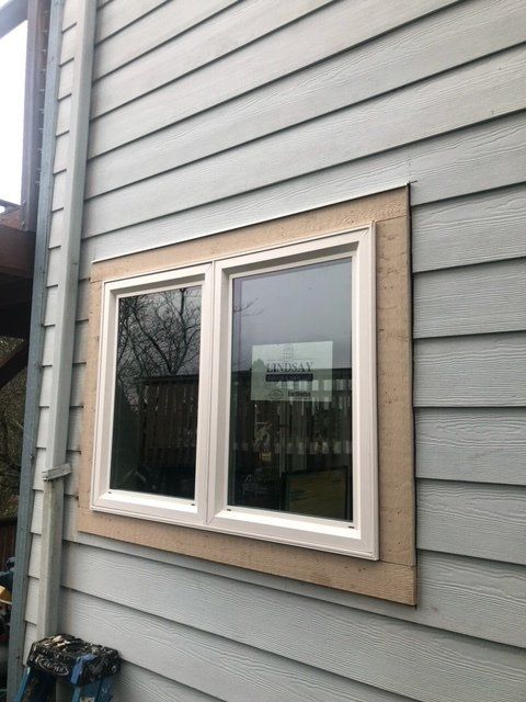 A window is being installed on the side of a house — Tukwila, WA — Bel-Red Windows & Doors