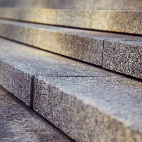 Stone steps, grey and textured, leading upwards.