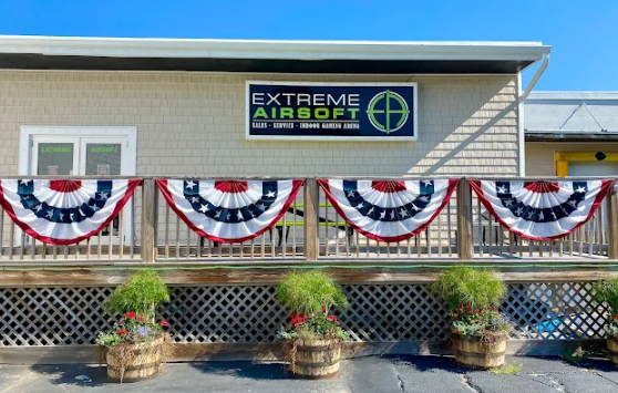 Exterior of Extreme Airsoft business with patriotic bunting and flower pots.