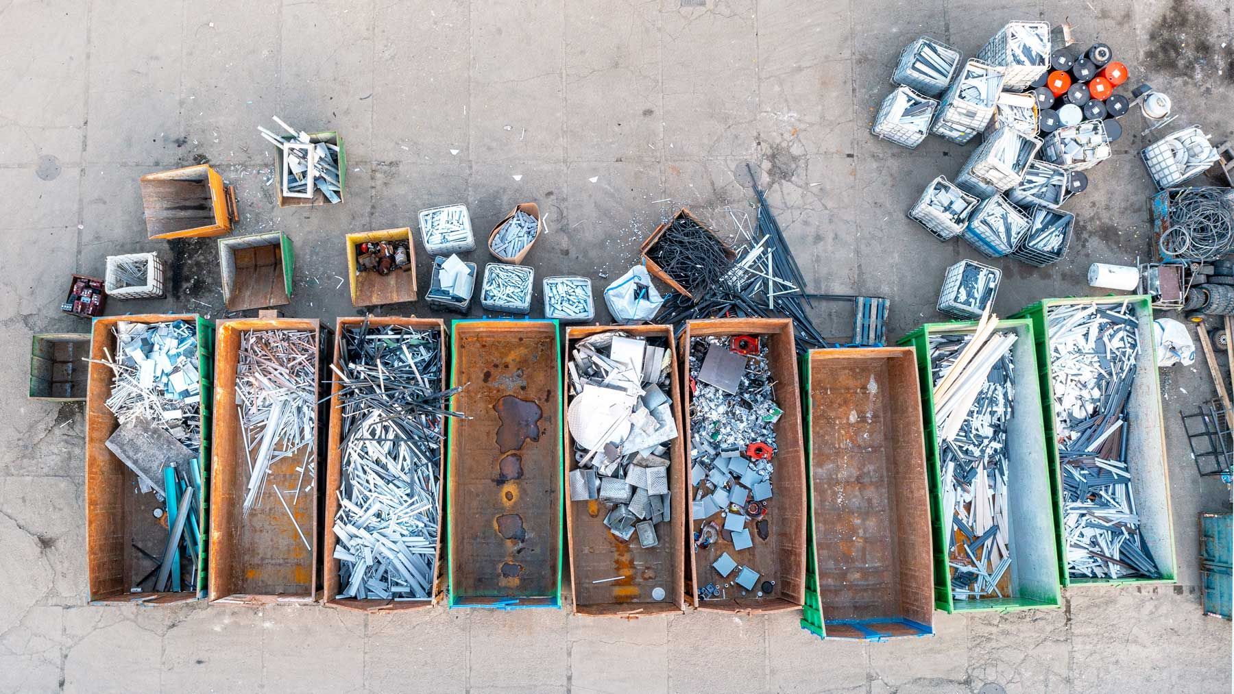 Large recycling bins filled with separated scrap metal ready for responsible recycling.