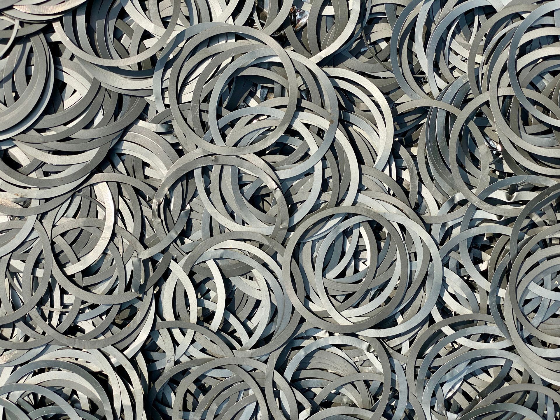 Pile of gray metal rings, densely packed together.