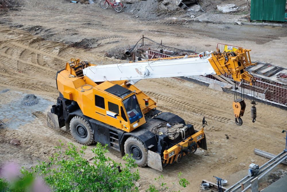 Yellow mobile crane on a construction site, lifting equipment. — Hannant Plant Hire in Robina, QLD