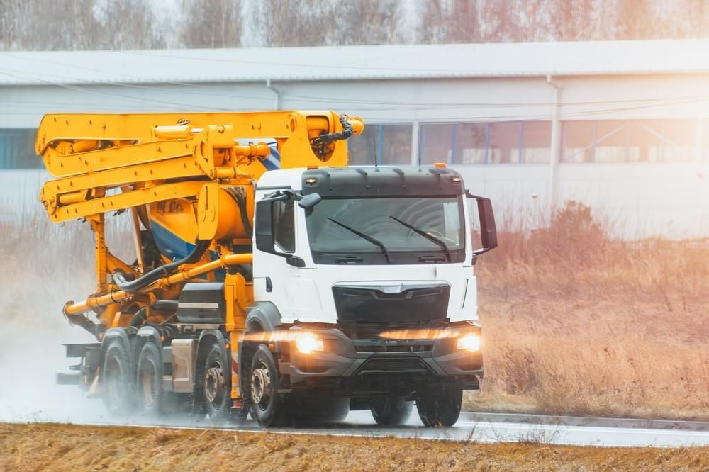 Concrete Pump Truck is Driving Down a Wet Road — Hannant Plant Hire in Robina, QLD