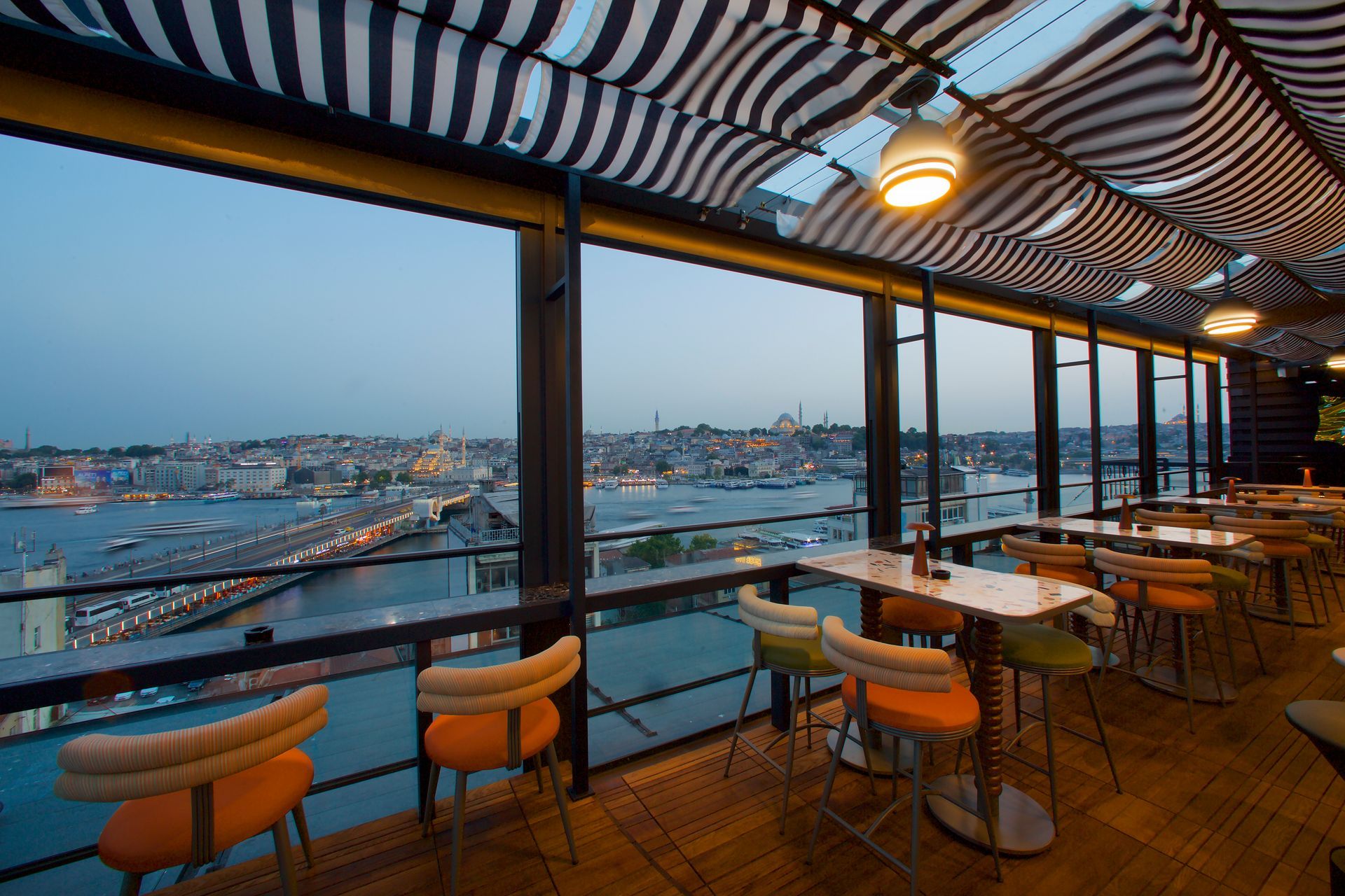 A restaurant with tables and chairs overlooking a body of water