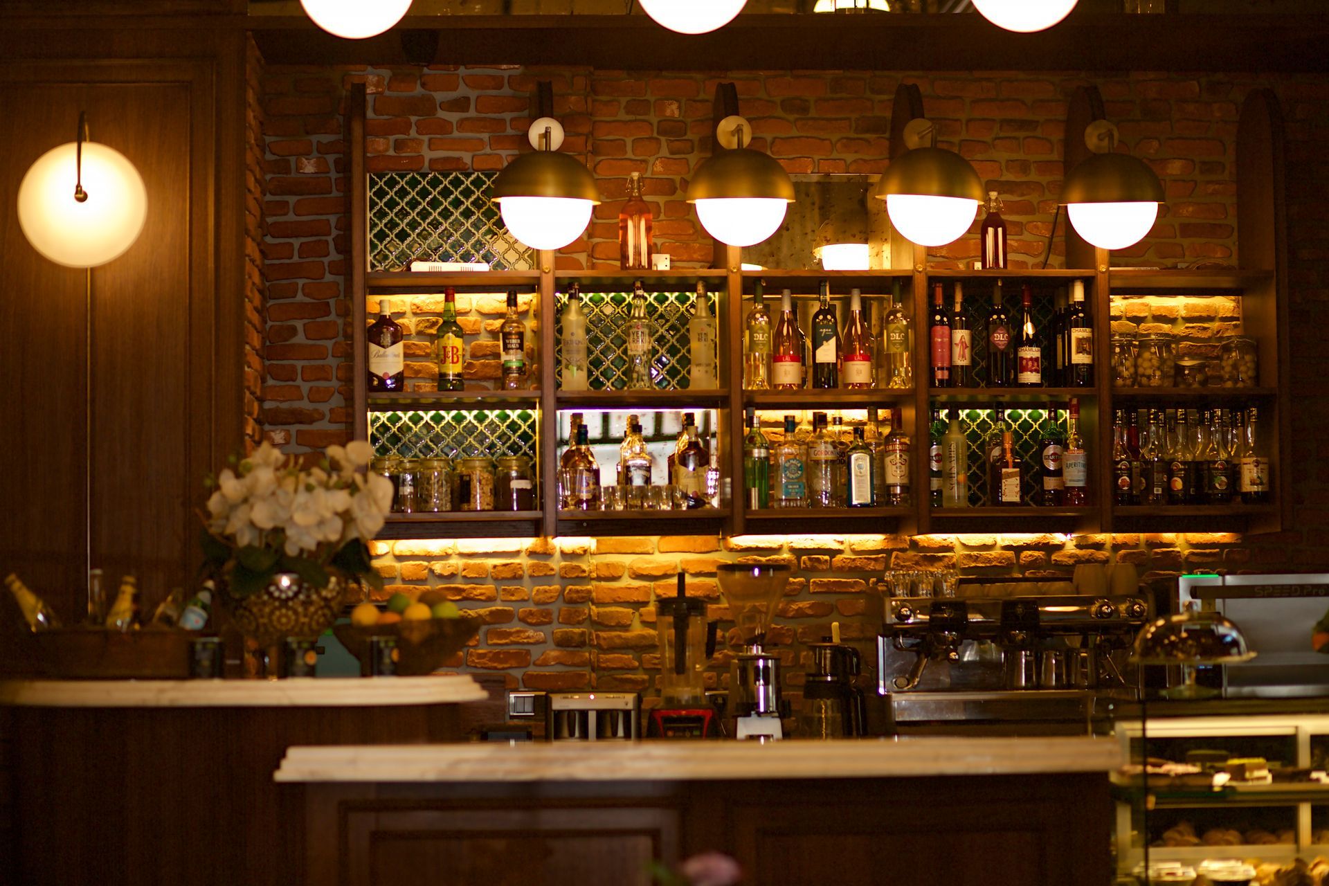 A bar with a brick wall and lots of bottles on shelves.