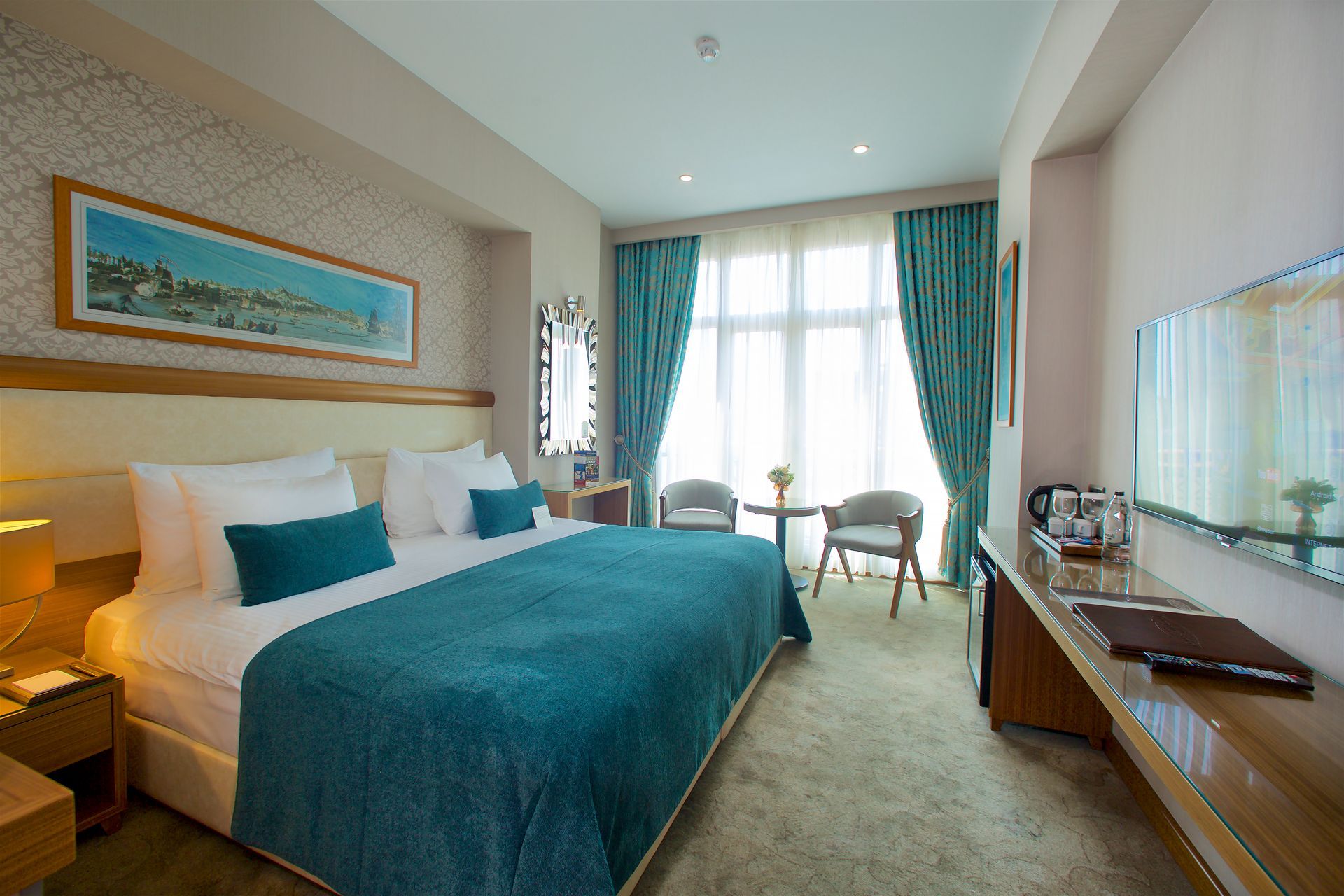 A hotel room with a king size bed and a flat screen tv.