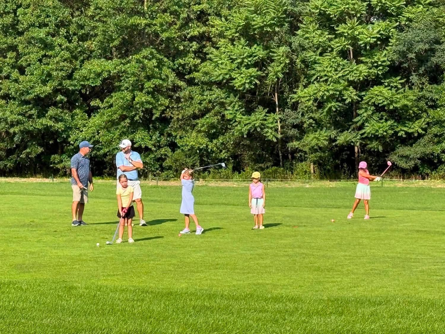 A group of people are playing golf on a golf course.