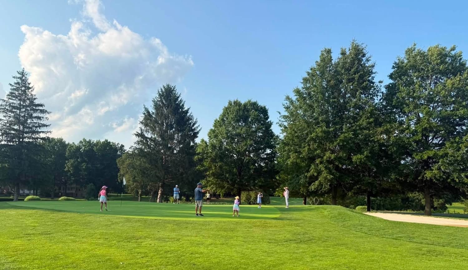 A group of people are playing golf on a golf course.