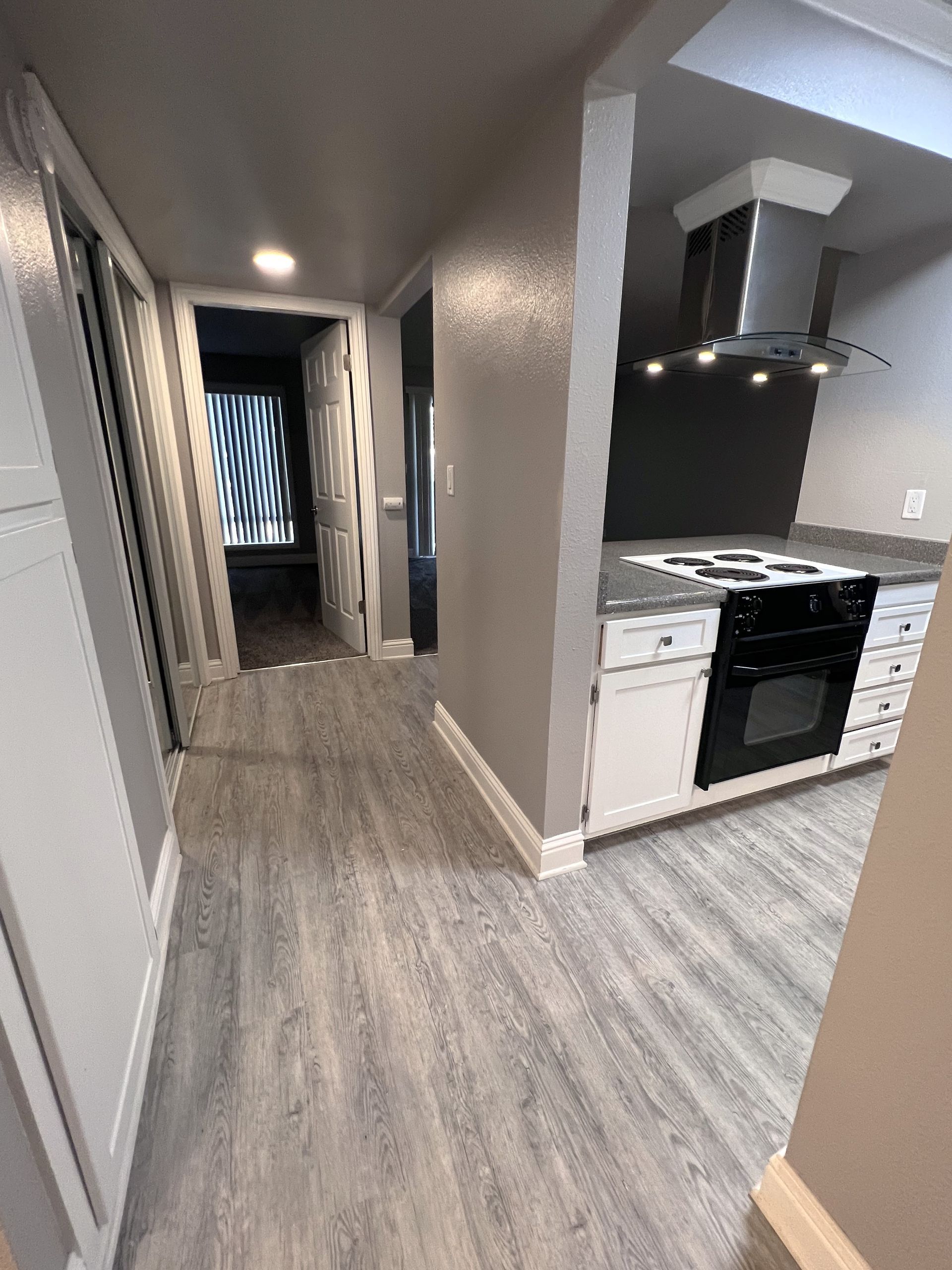 a kitchen with white cabinets and a black stove top oven