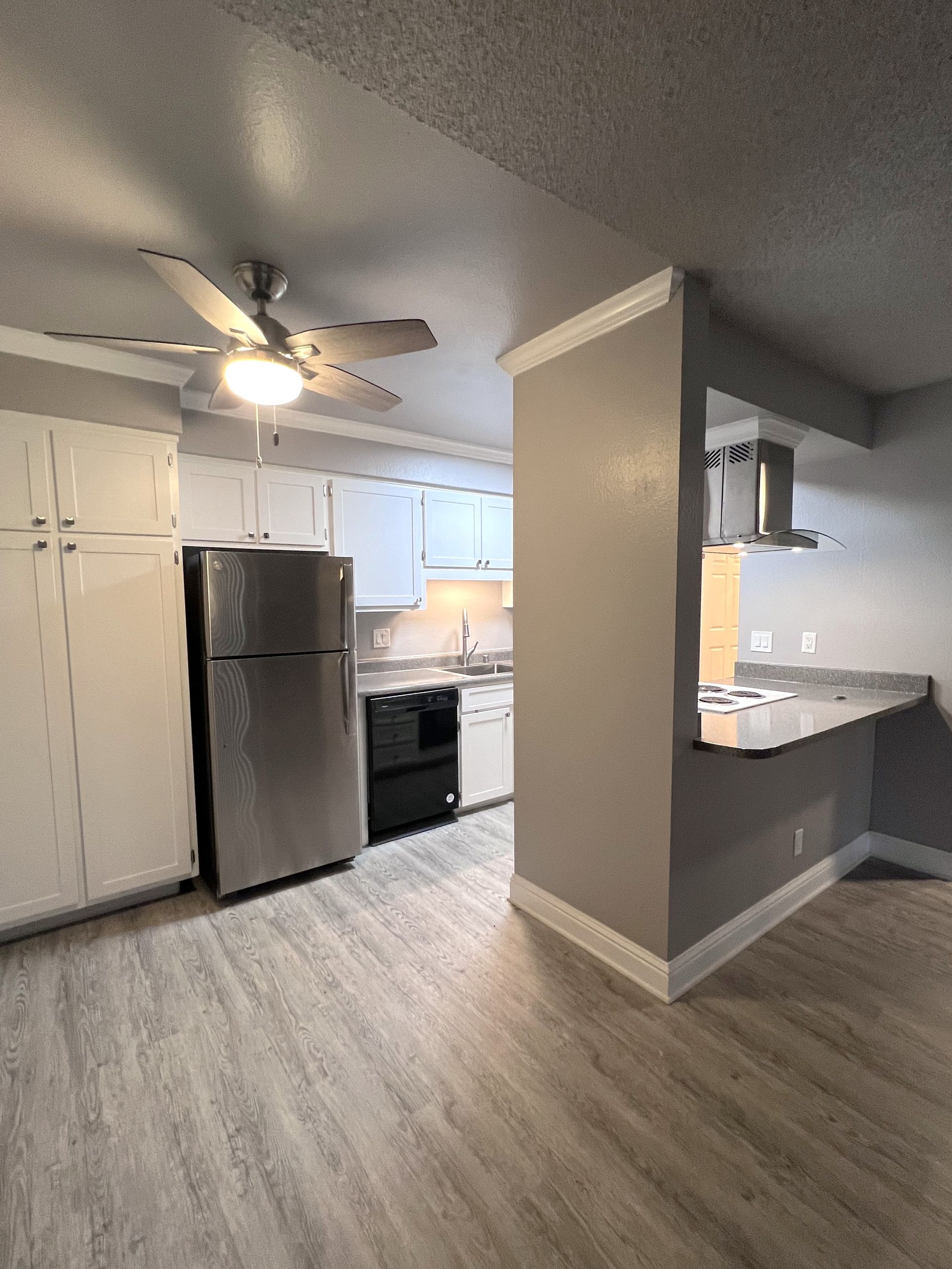 a kitchen with white cabinets and a stainless steel refrigerator