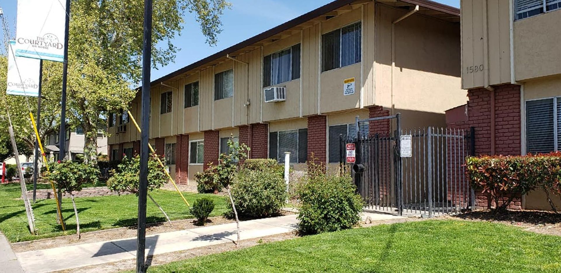 Image of front of building with bushes and the numbers 1580