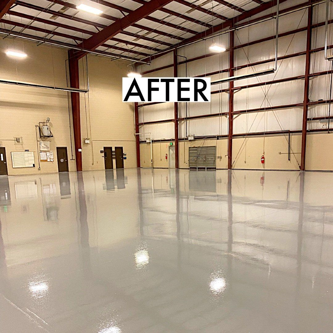 Newly painted, shiny grey warehouse floor reflecting overhead lights; 