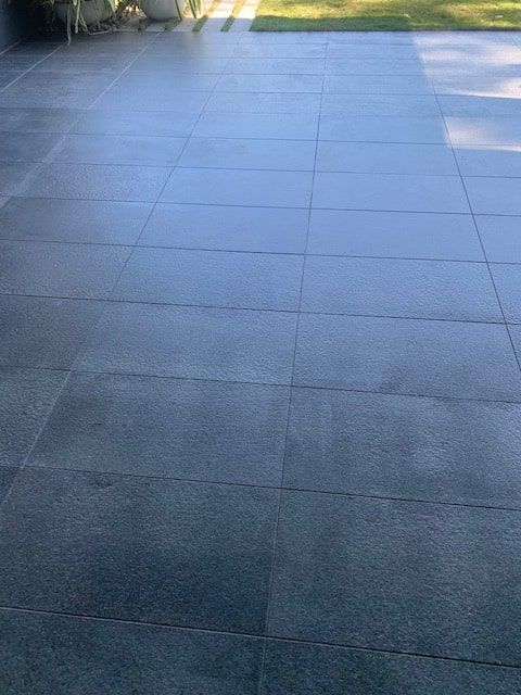 A Patio With a Lot of Tiles on It and a Lawn in the Background — The Tile & Stone Specialists in Peregian Beach, QLD