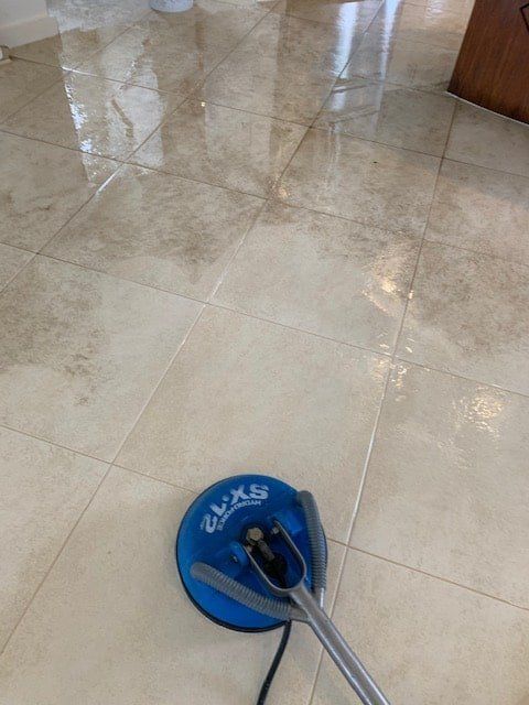 A Vacuum Cleaner is Sitting on a Tiled Floor — The Tile & Stone Specialists in Peregian Beach, QLD