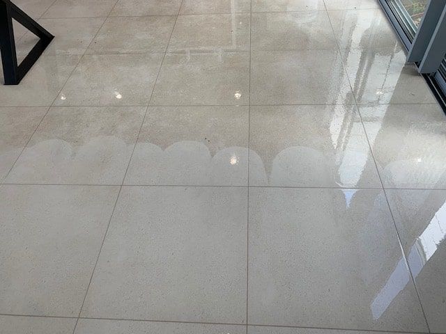 A Tiled Floor With a Reflection of a Building in It — The Tile & Stone Specialists in Peregian Beach, QLD