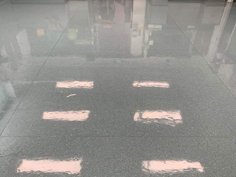 A Gray Carpeted Floor With White Arrows on It — The Tile & Stone Specialists in Peregian Beach, QLD
