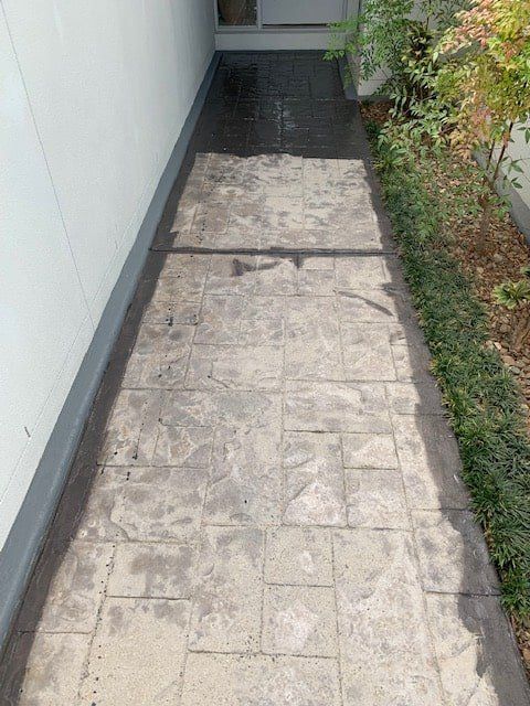 A Concrete Walkway Leading to a Doorway Next to a Building — The Tile & Stone Specialists in Peregian Beach, QLD