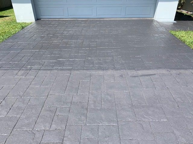 A Brick Driveway Leading to a Blue Garage Door — The Tile & Stone Specialists in Peregian Beach, QLD