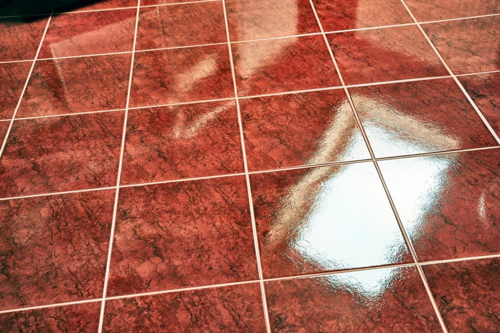 A Red Tile Floor With a Reflection of a Window — The Tile & Stone Specialists in Peregian Beach, QLD