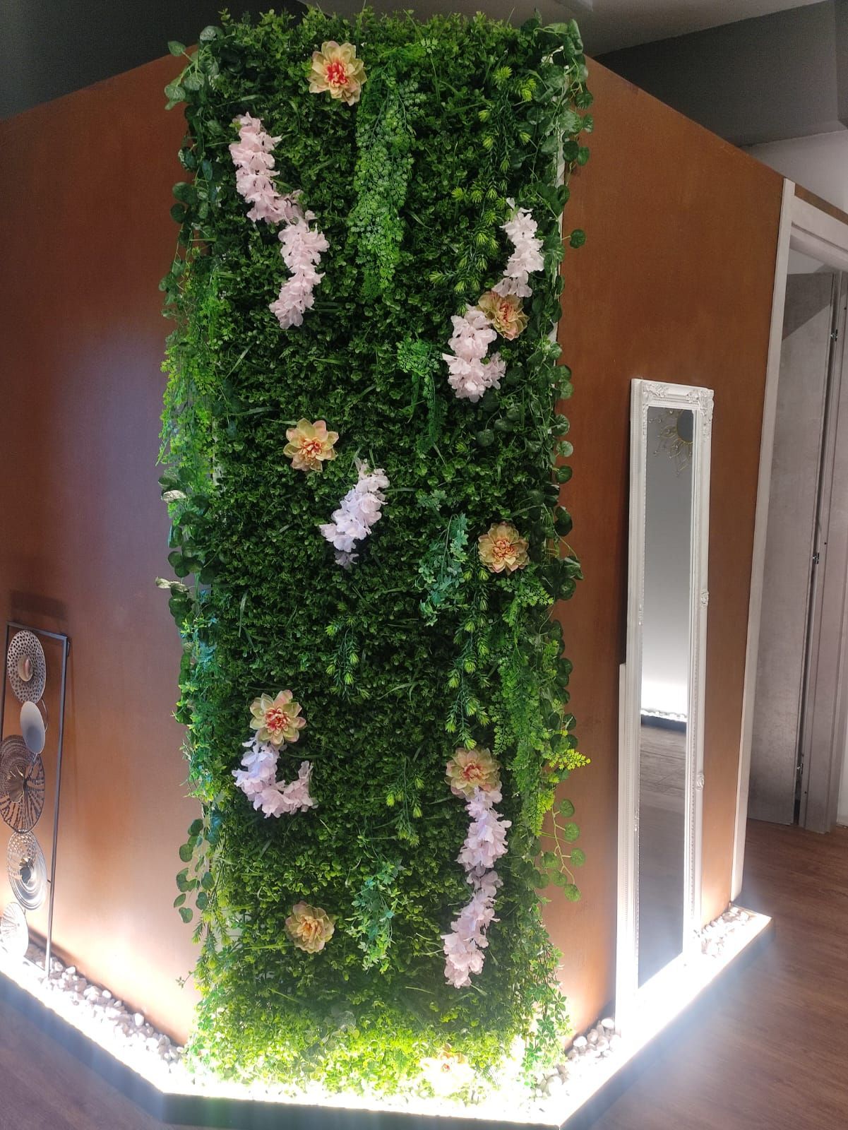 Una parete verde con dei fiori in una stanza.