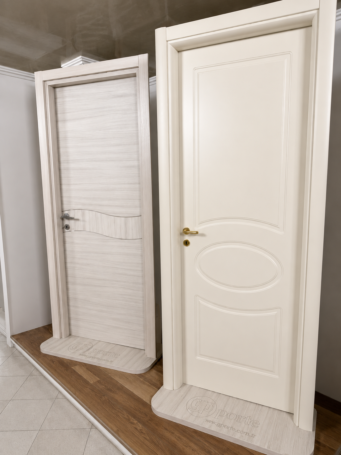 In uno showroom sono esposte due porte interne bianche, una con inserto a tenda e l'altra con dettagli a pannello ovale.