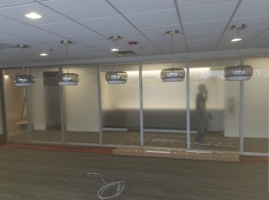 A room with a lot of windows and lamps hanging from the ceiling