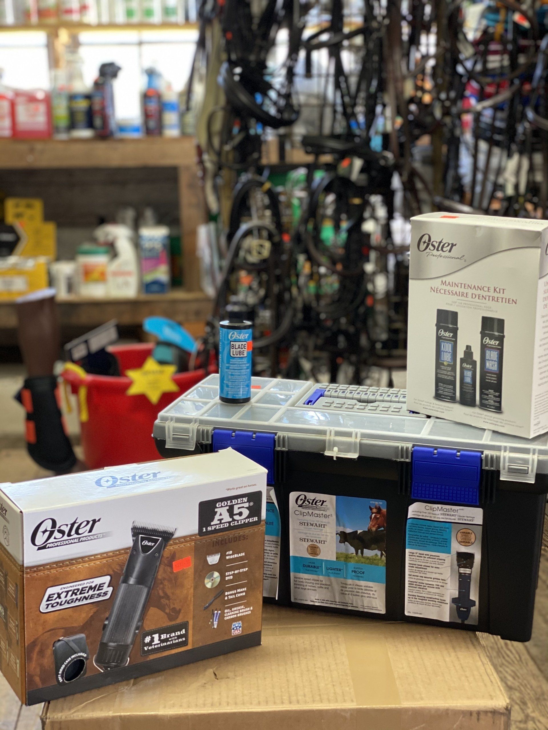 Assorted boxed grooming products on a counter in a shop aisle, with shelves of supplies in the background.