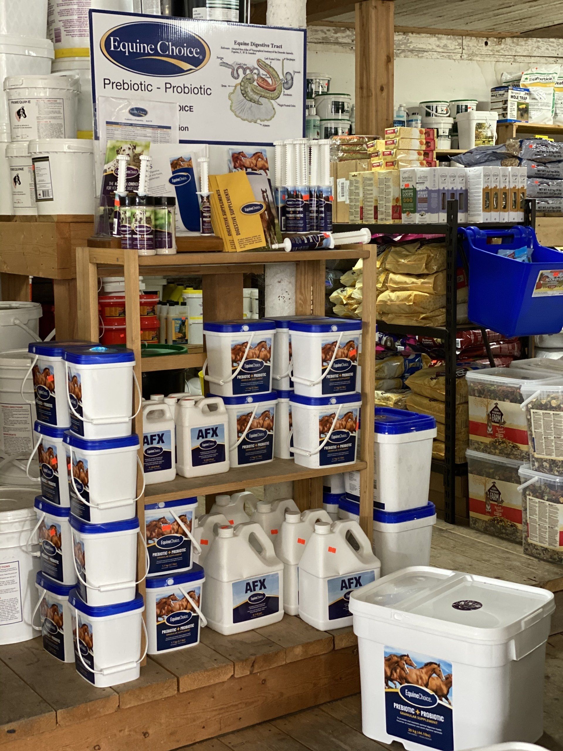 Display of packaged food products on store shelves, with white tubs and blue-labeled containers in a retail aisle
