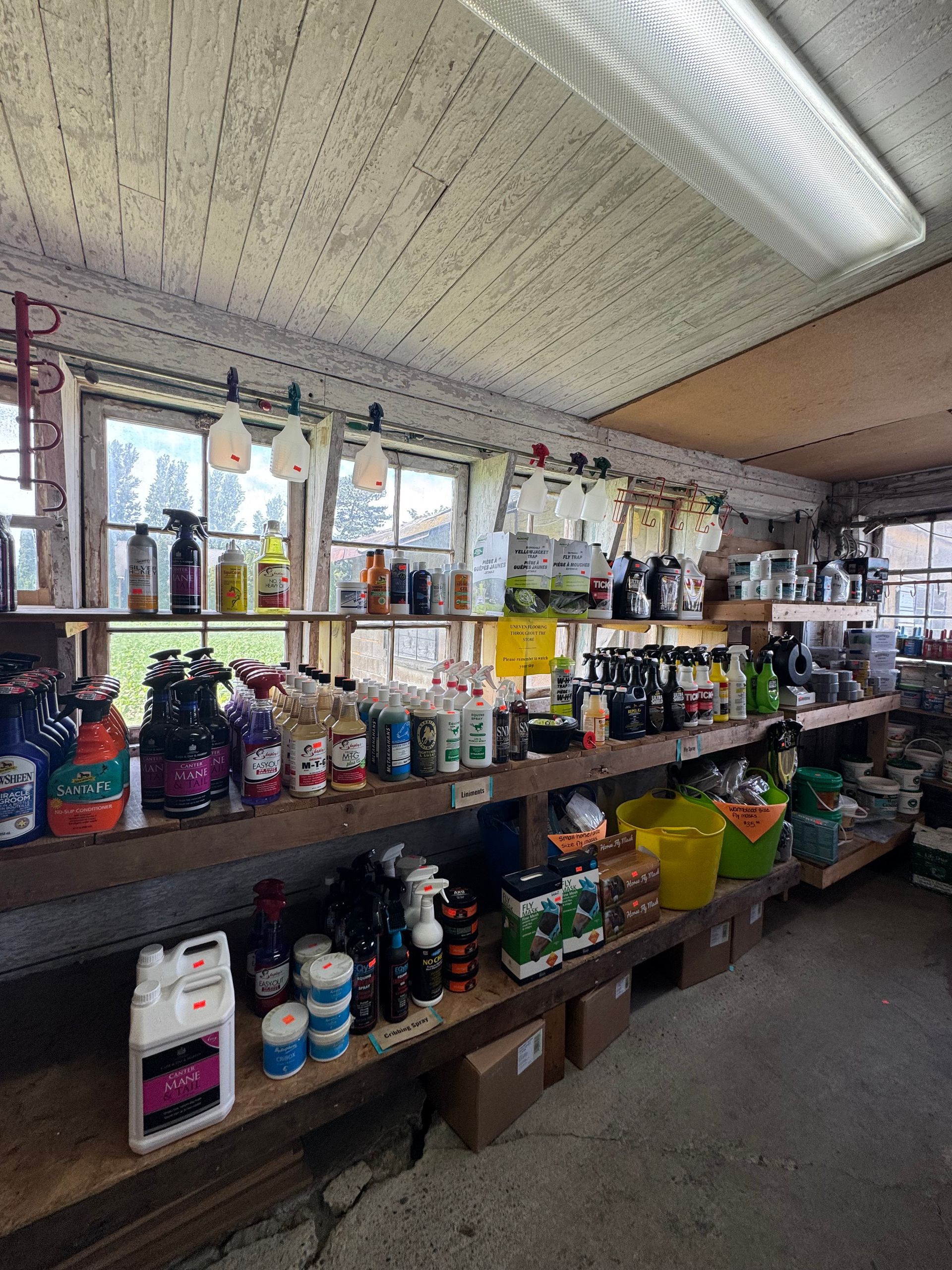 Shelves of assorted bottles and cleaning supplies in a dim indoor market or storage area