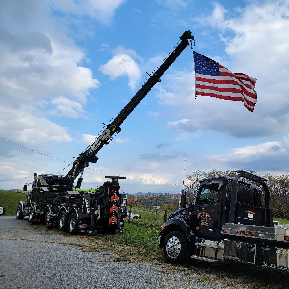 Tow trucks with US flag extended, on a cloudy day.