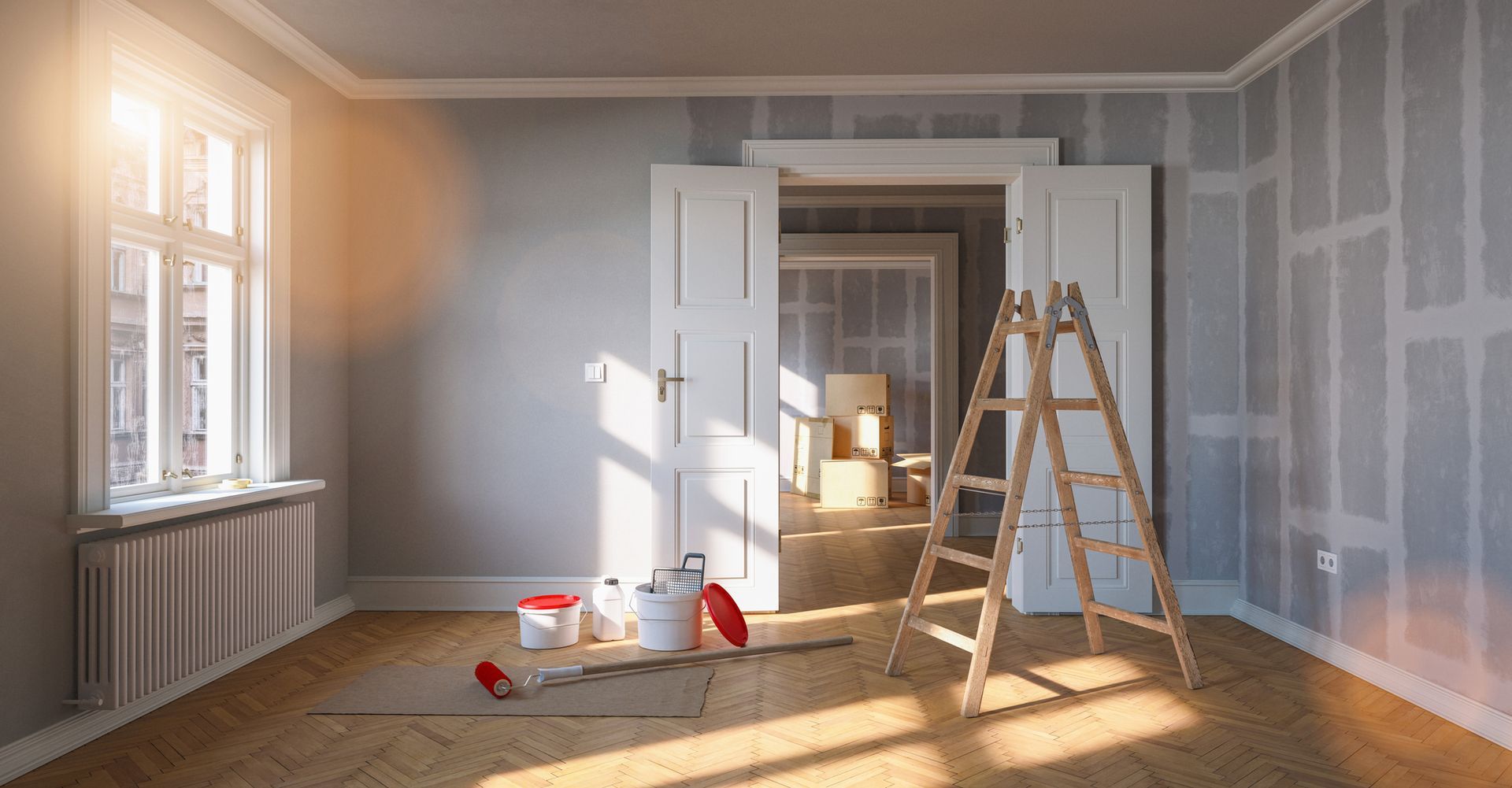 Stanza luminosa in fase di ristrutturazione con scala, barattoli di vernice e luce del sole che filtra dalle finestre.
