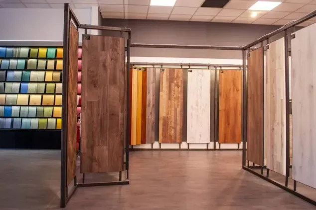 Showroom con esposizione di pavimenti in legno e pannelli campione sospesi in tonalità neutre.