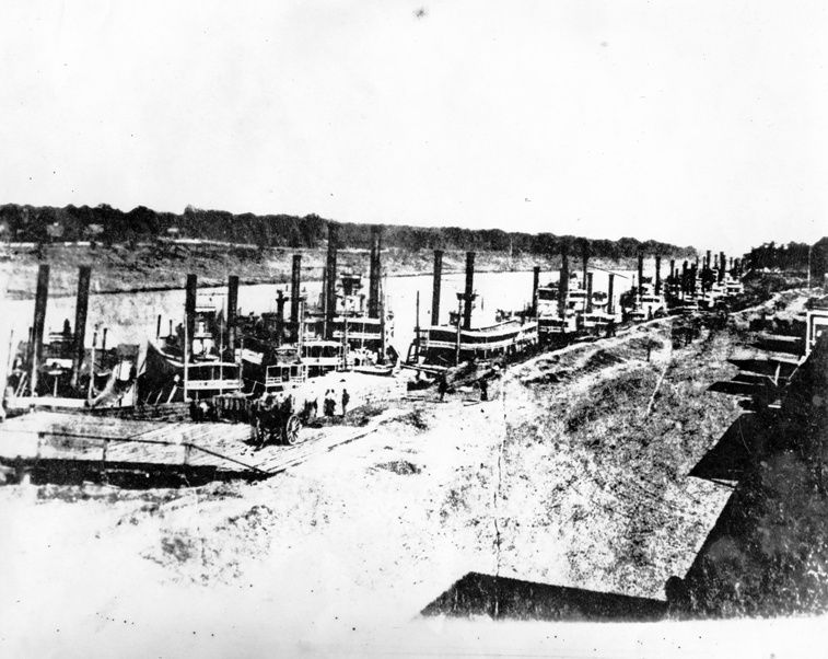 A black and white photo of a river with boats in it