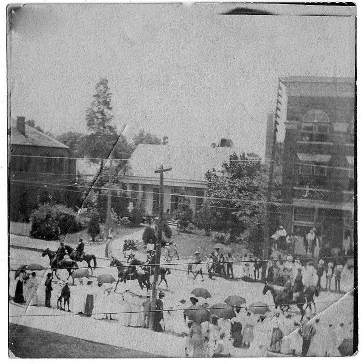 A black and white photo of people riding horses