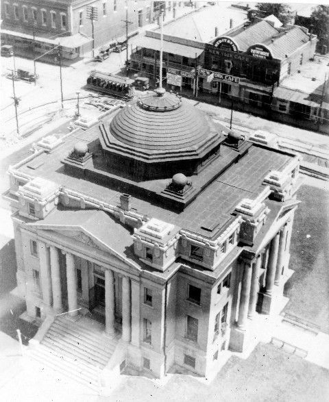 A black and white photo of a large building with a dome on top