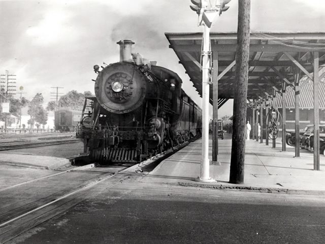 A black and white photo of a train at a station