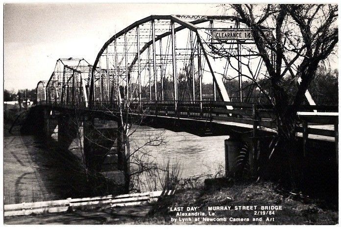 A black and white photo of a bridge over a river
