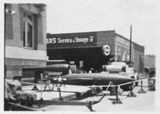 A black and white photo of a jet parked in front of a building.