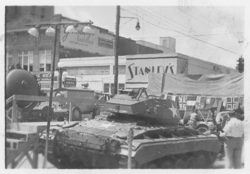 A black and white photo of a tank in front of a store called stanley 's