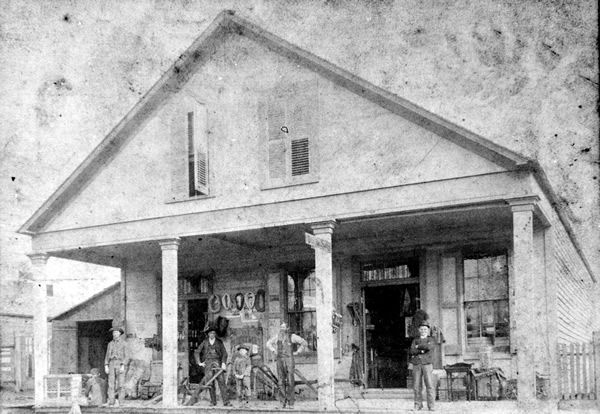 A black and white photo of a house with a porch
