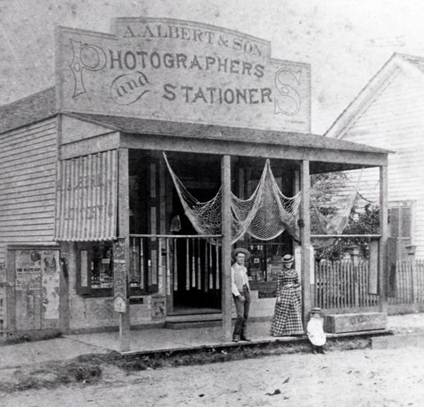 A black and white photo of a store called albert & son photographers and stationer
