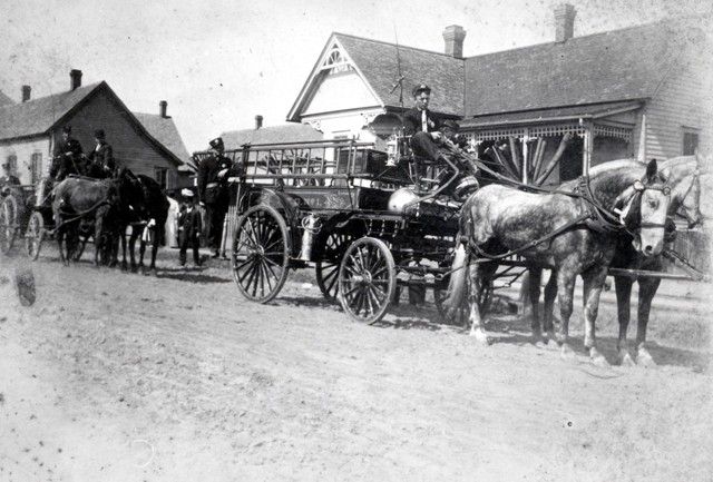A black and white photo of a horse drawn carriage