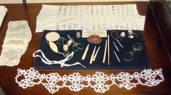 A table with a variety of objects on it including a piece of lace