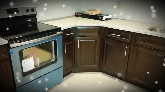 Kitchen with dark wood cabinets, light countertop, and stainless steel oven on the left.