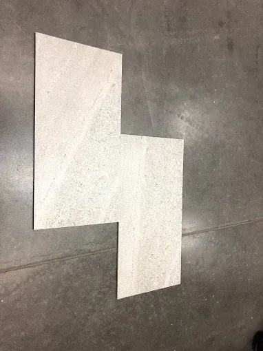 Two overlapping white paper sheets on a gray floor, arranged in an offset L shape.